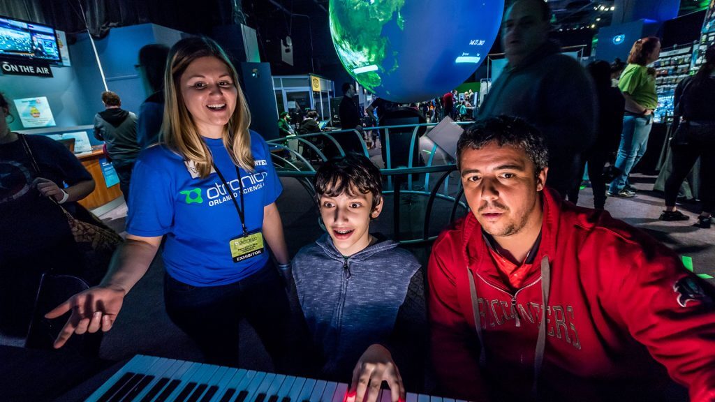 Adult volunteer during the Otronicon event interacting with guests.