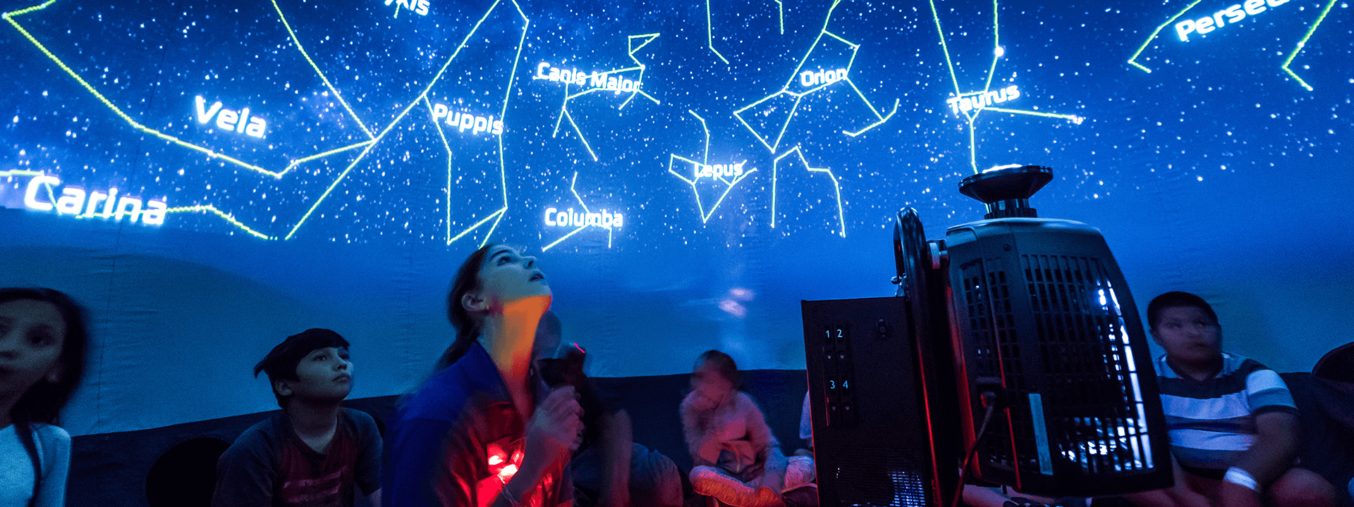 A group of children watch a presentation in the mobile planetarium as part of offerings for educators and students.