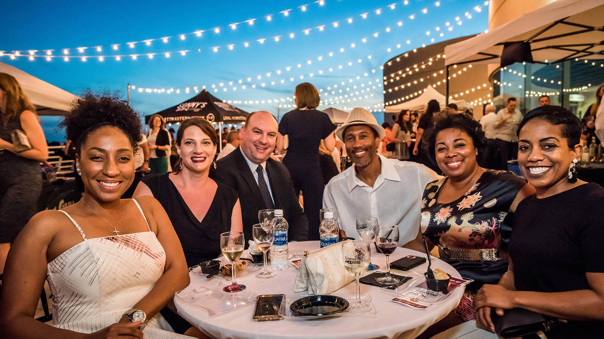 A group of friends enjoying food and drinks on the terrace.