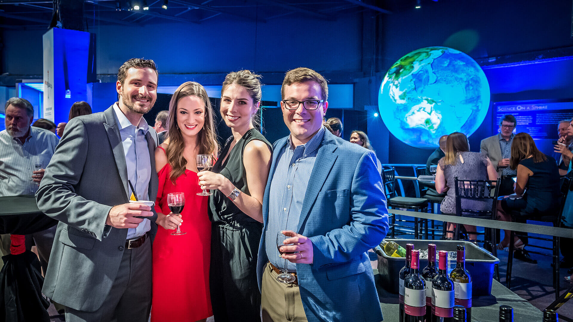 A group of friends with glasses of wine in one of the Science Center's exhibits.