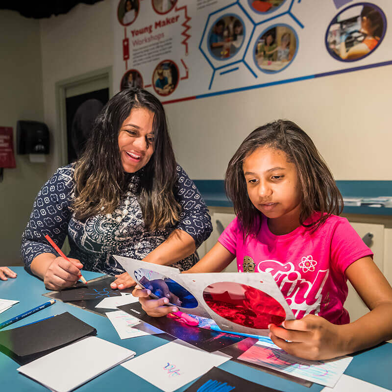 A mother and her children examining colored filtered in an experiment about light.