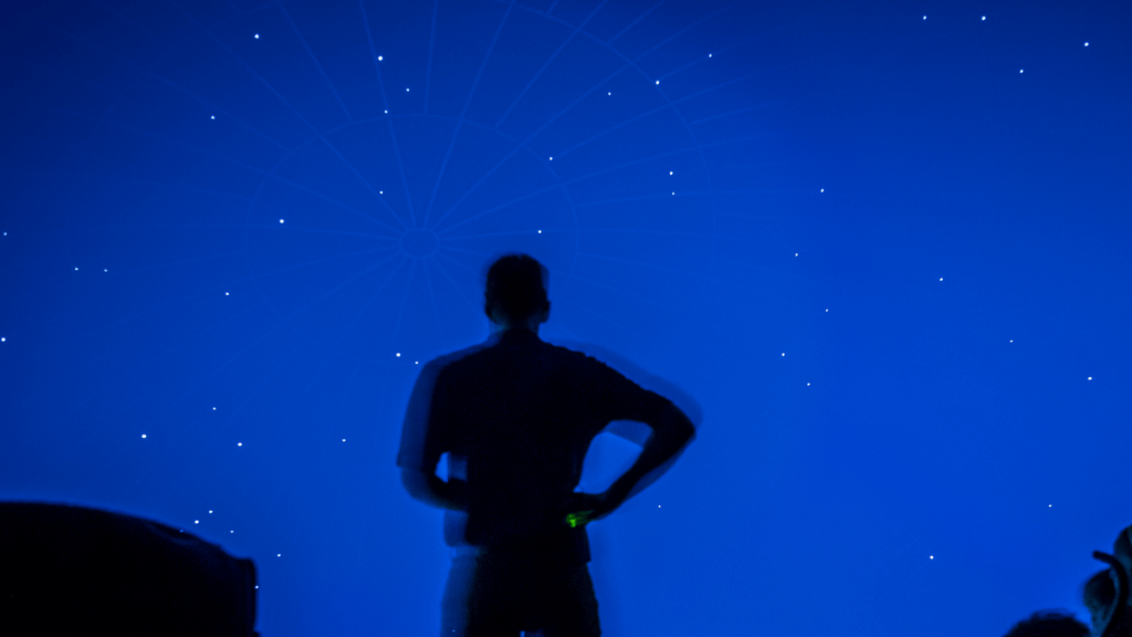 silhouette of a man standing in front of observatory