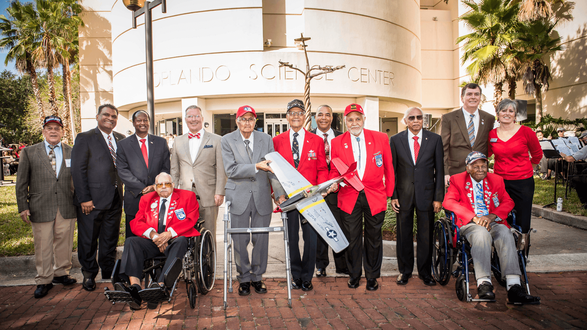 Group standing in front of red tails monument