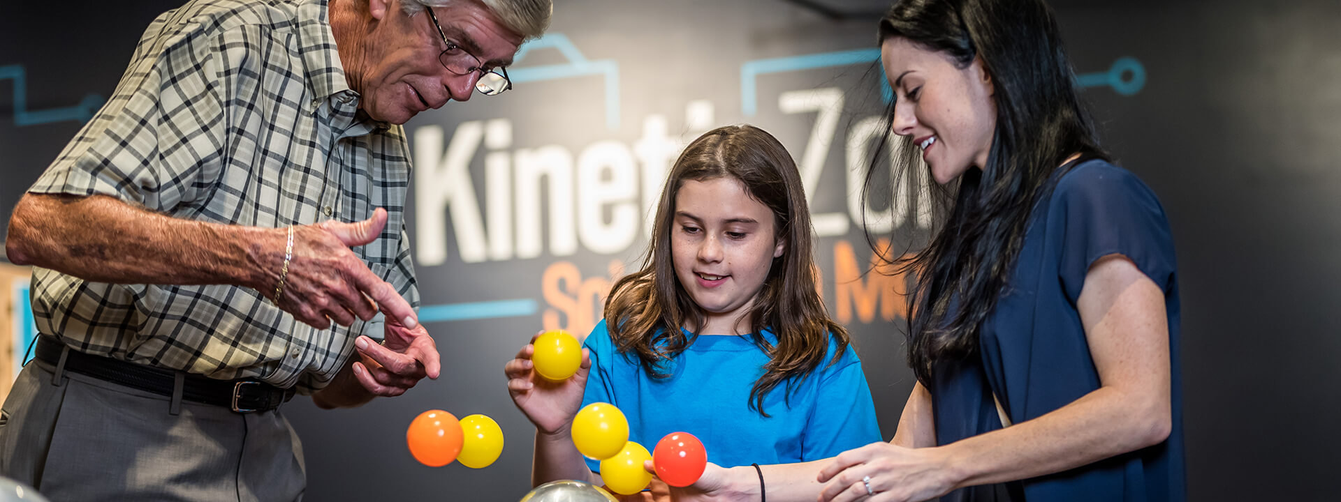 A family balancing plastic balls in the air with the air resistance exhibit.