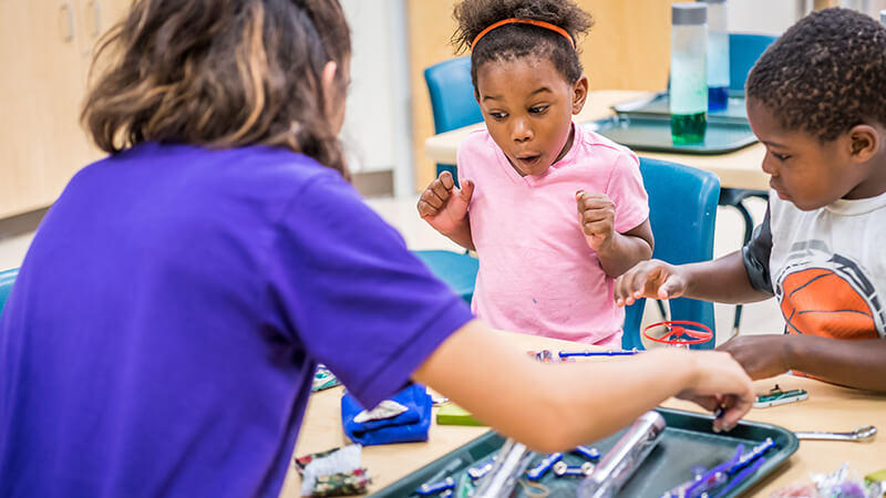 children looking amazed at a science experiment