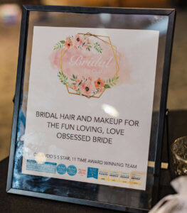 A sign reading: Bridal and makeup for the fun loving, love obsessed bride