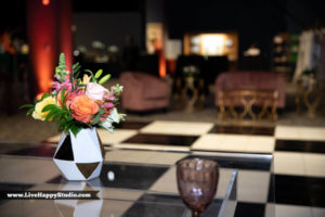 flowers in a checked vase with a checkered dance floor in the background 