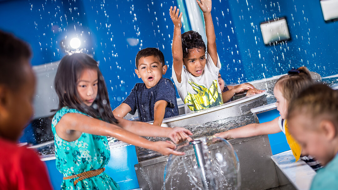Group of children playing in interactive water play area in Orlando Science Center's children's exhibit