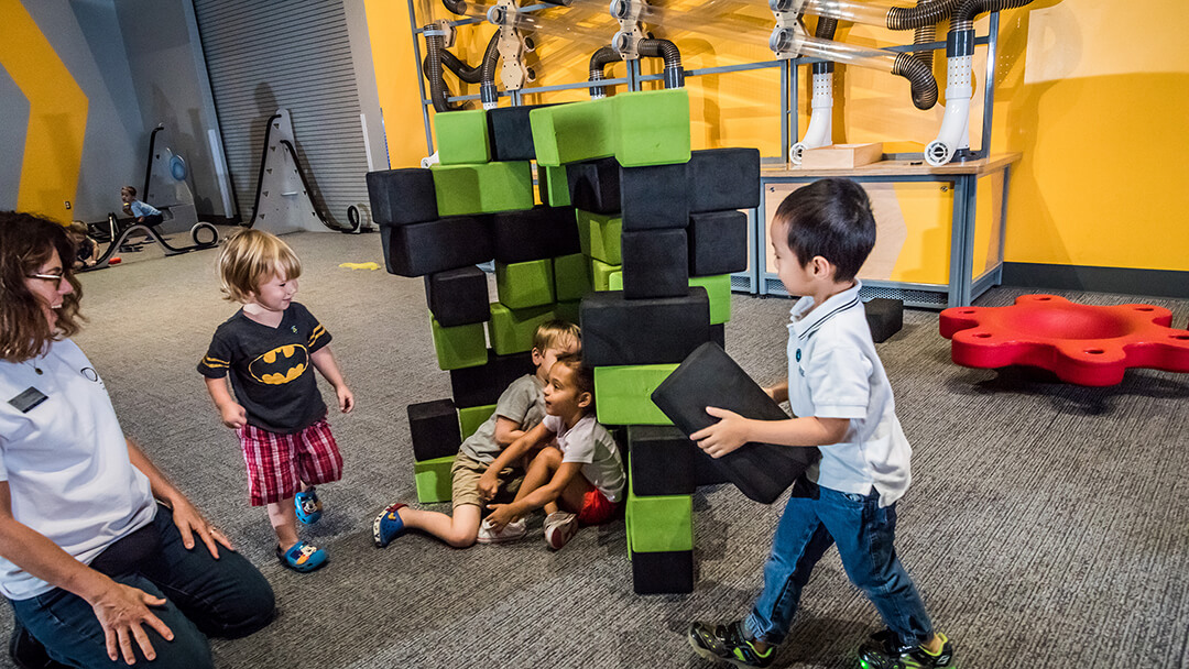 Children building with foam blocks in exploration-based early childhood exhibit