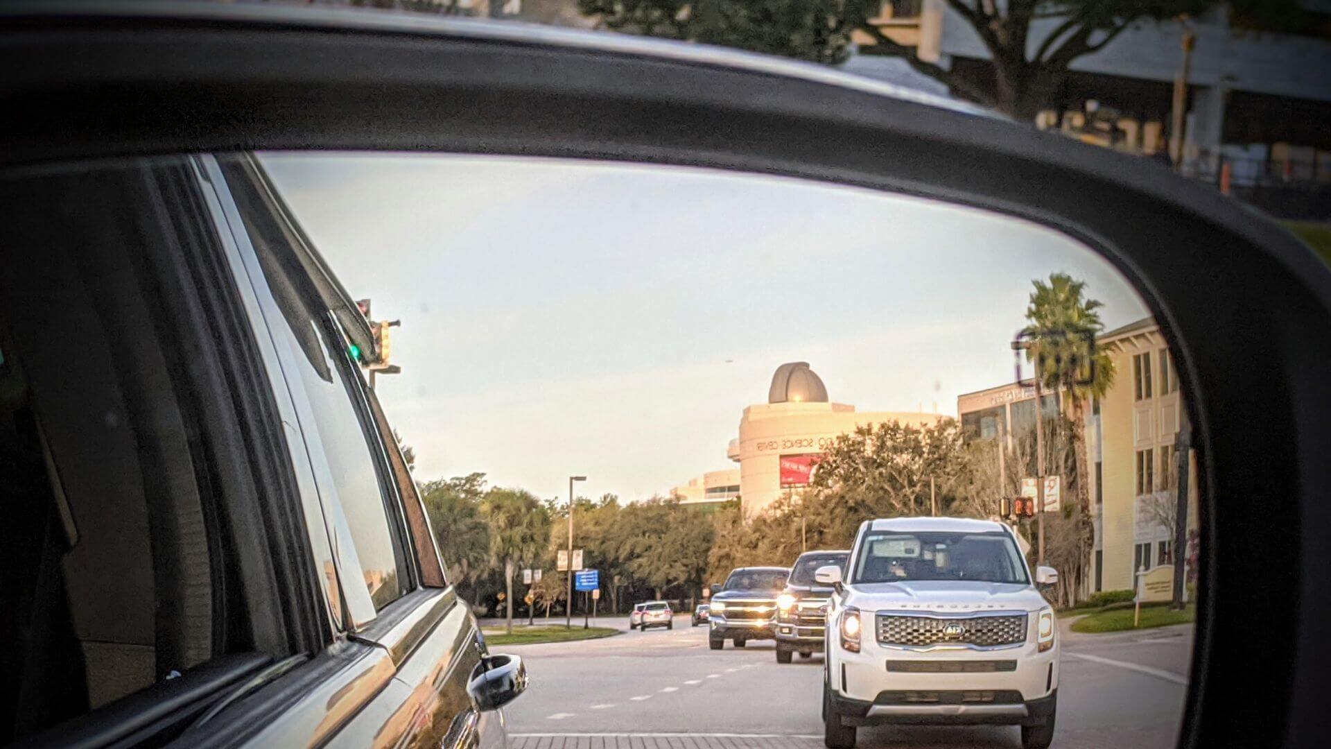 Orlando Science Center in the rearview mirror of a car