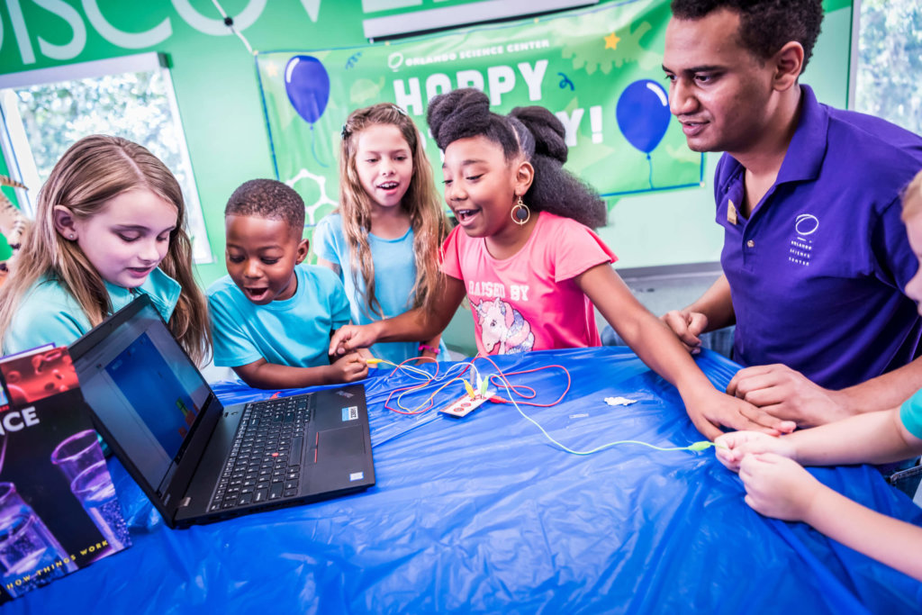 a group of kids at a birthday party doing a computer project