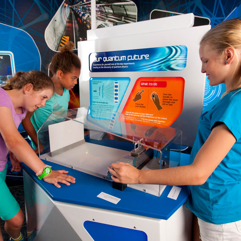 Science Fiction, Science Future - three kids playing with the Quantum Future exhibit.