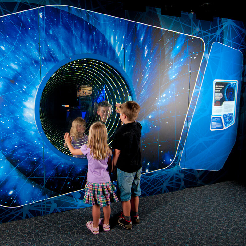 Science Fiction, Science Future - two kids staring deep into the Wormhole exhibit.