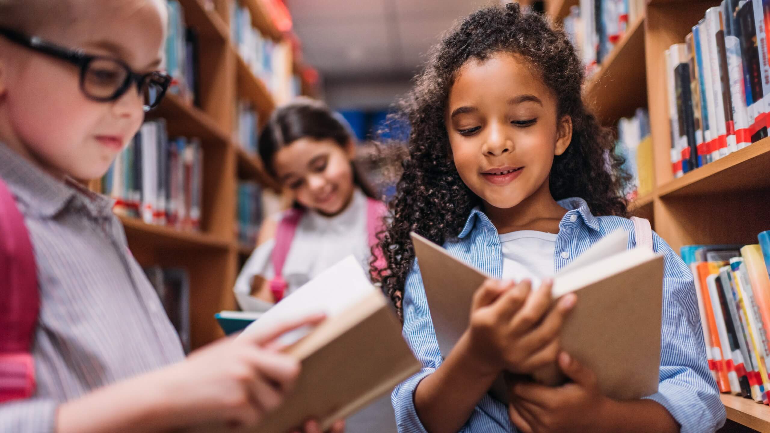 schoolgirls looking for books in a library