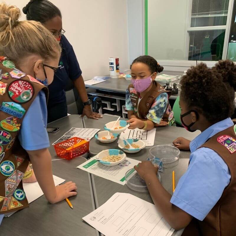 a group of Girl Scouts collaborating on a STEM project