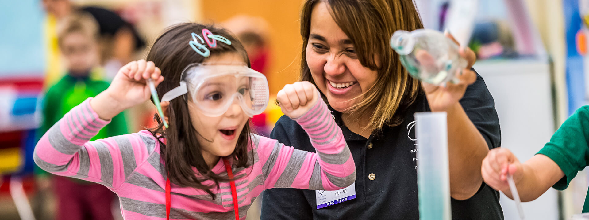 A preschool student shows her excitement during a chemistry experiment.