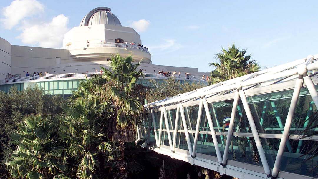 Daytime photo of Orlando Science Center building exterior with crowd of people on the Terrace.