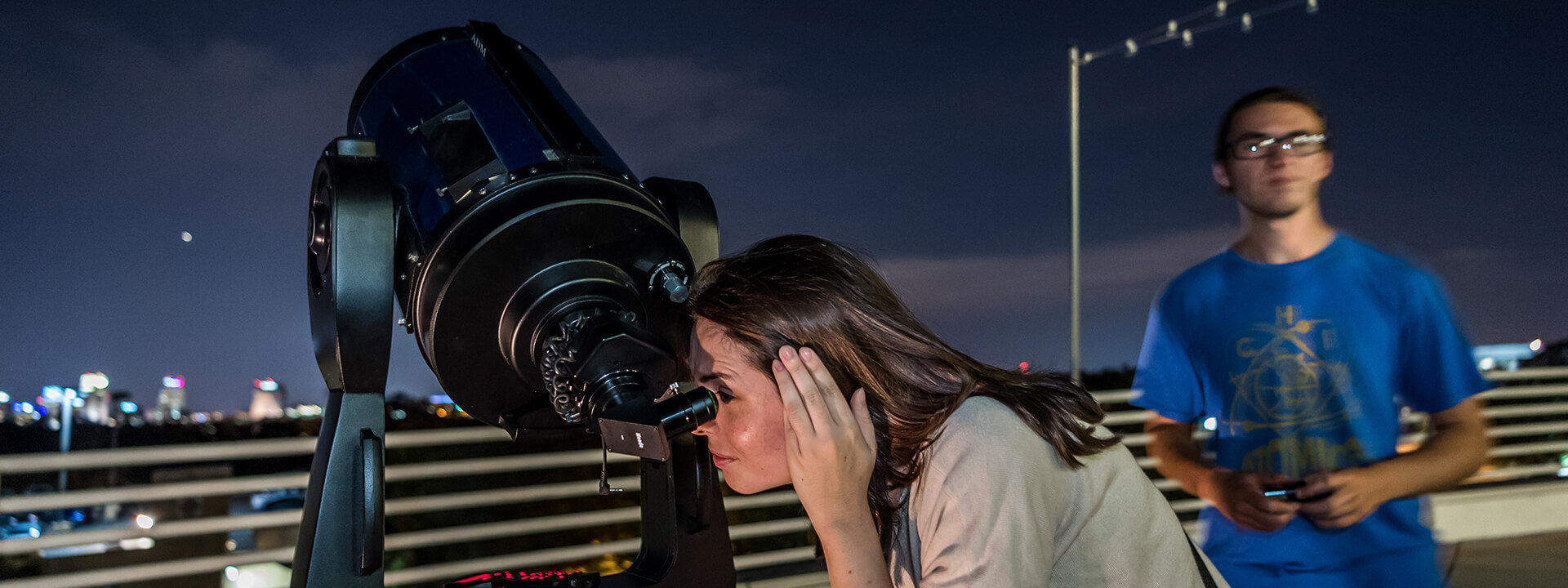 Guest stargazing through telescope outside on the Terrace at Orlando Science Center.