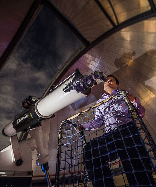 A guest looking through the refractor telescope in the observatory.