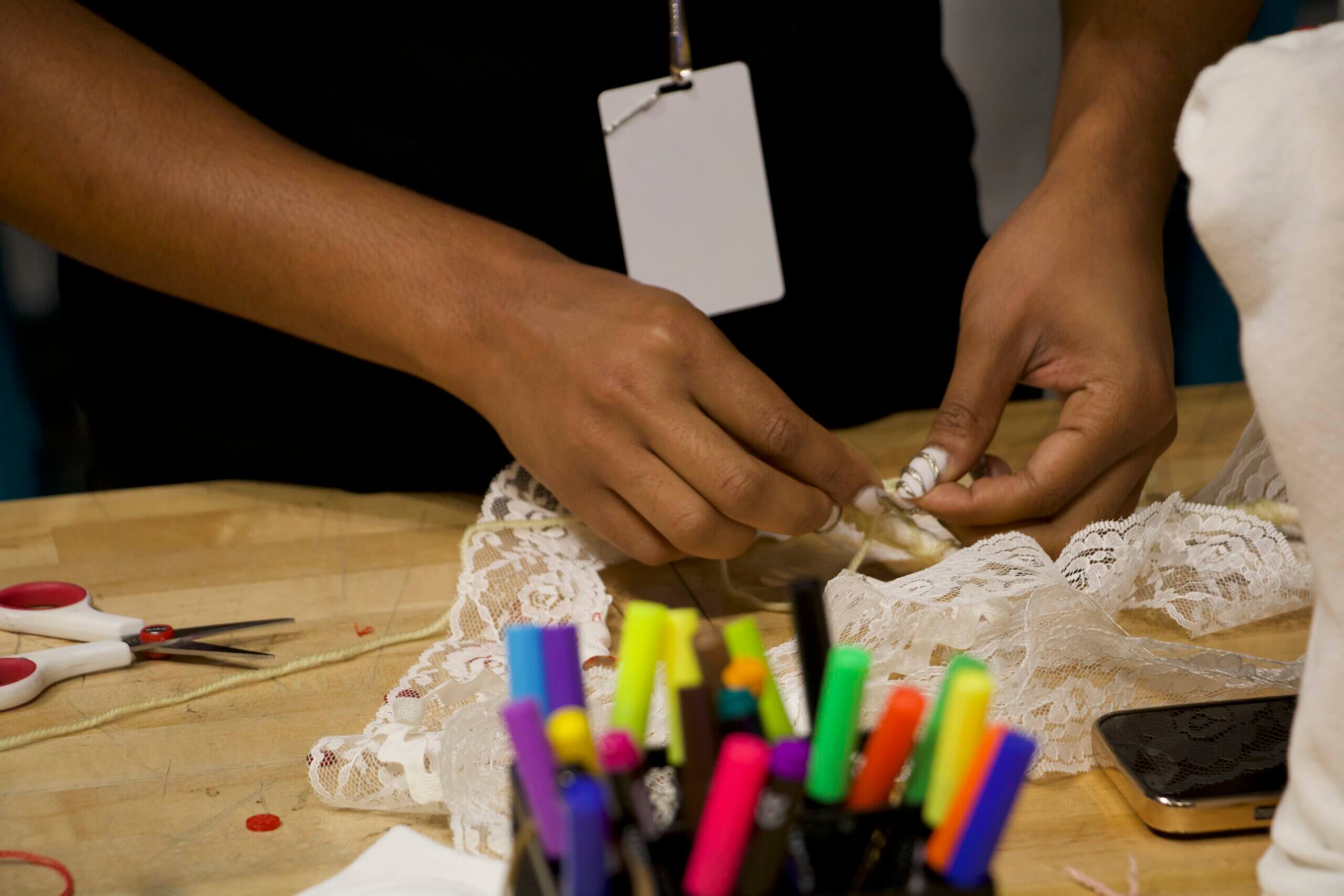 a man sews buttons onto a sock puppet
