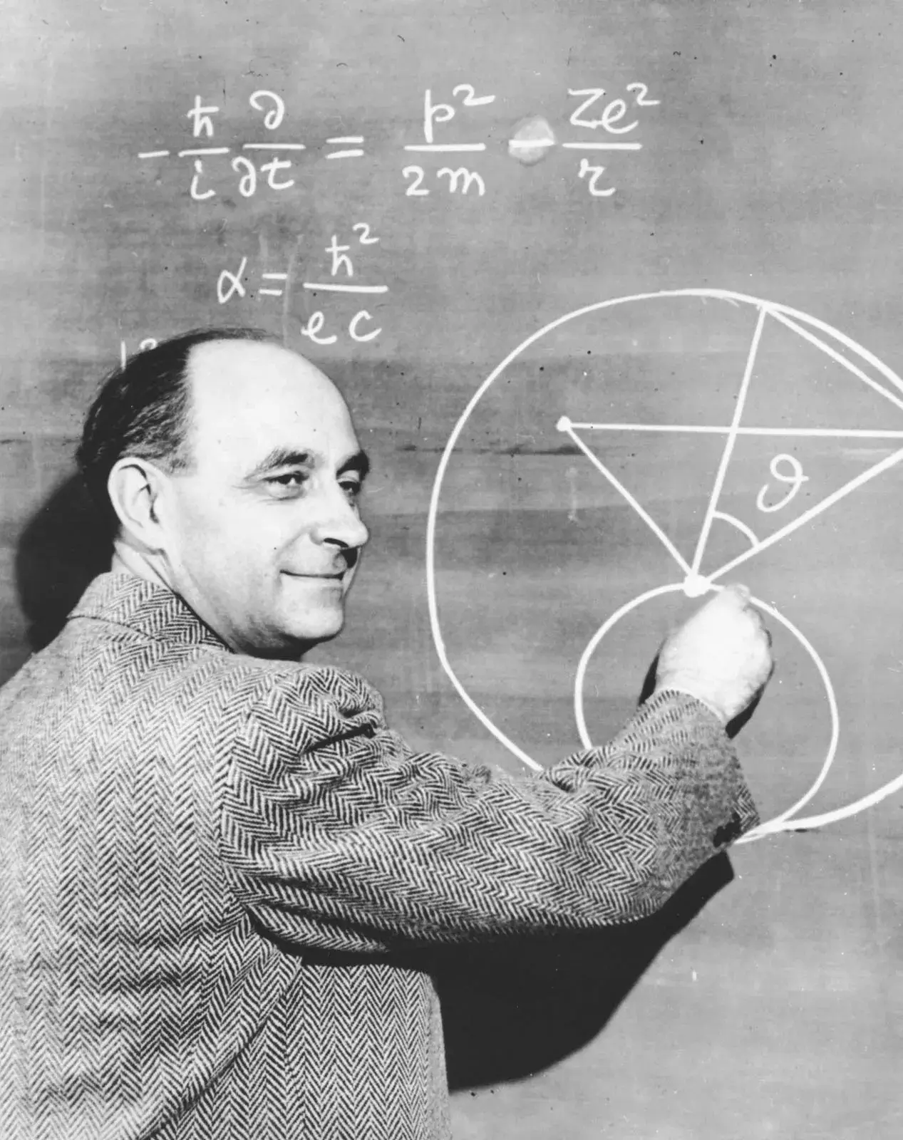 Enrico Fermi completes a physics equation on a chalkboard.