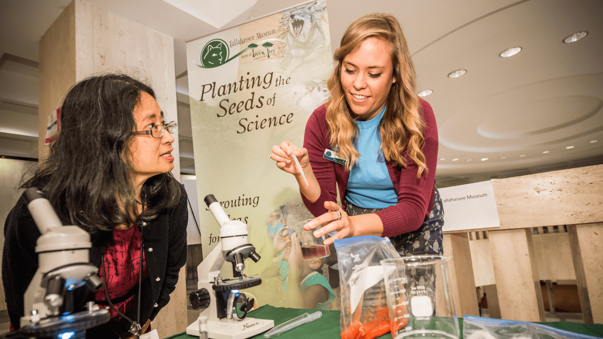 A woman demonstrates a chemical reaction during STEM Day at the Capitol.
