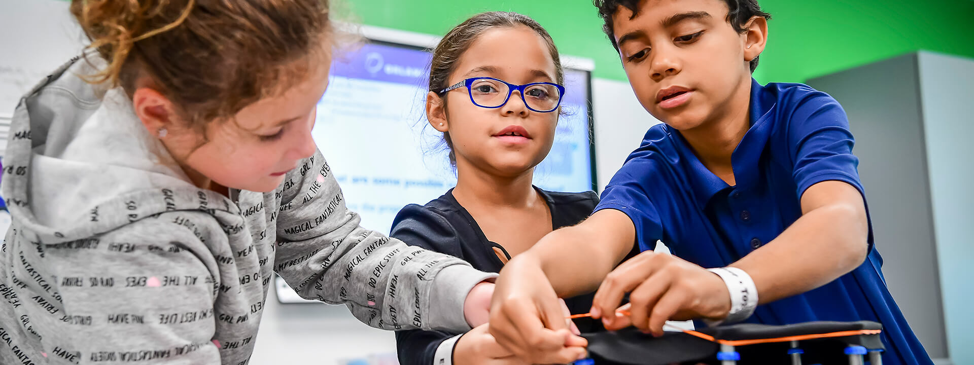 Three students participating together in a hands-on lab activity from Orlando Science Center.