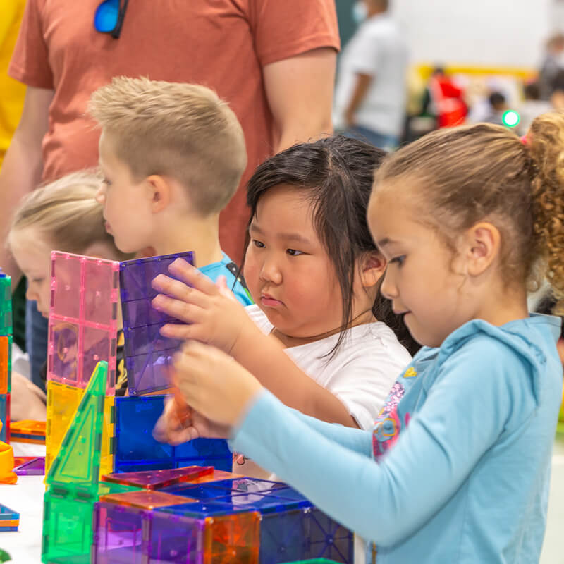 Young students participating together in a hands-on Science Festival activity from Orlando Science Center.