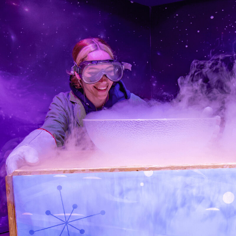 Cool-Science_800x800 A young person in safety goggles smiles over a bowl of liquid nitrogen steam