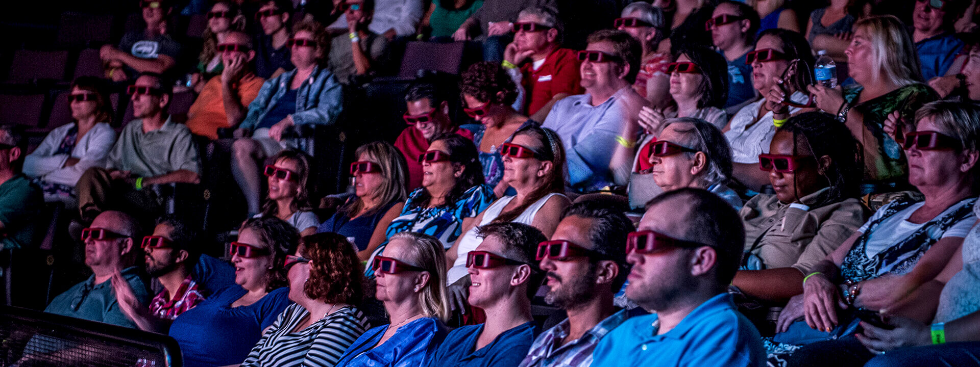 Digital-Adventure-Theater-Header_1920x720 Guests wearing 3D glasses enjoying a film.