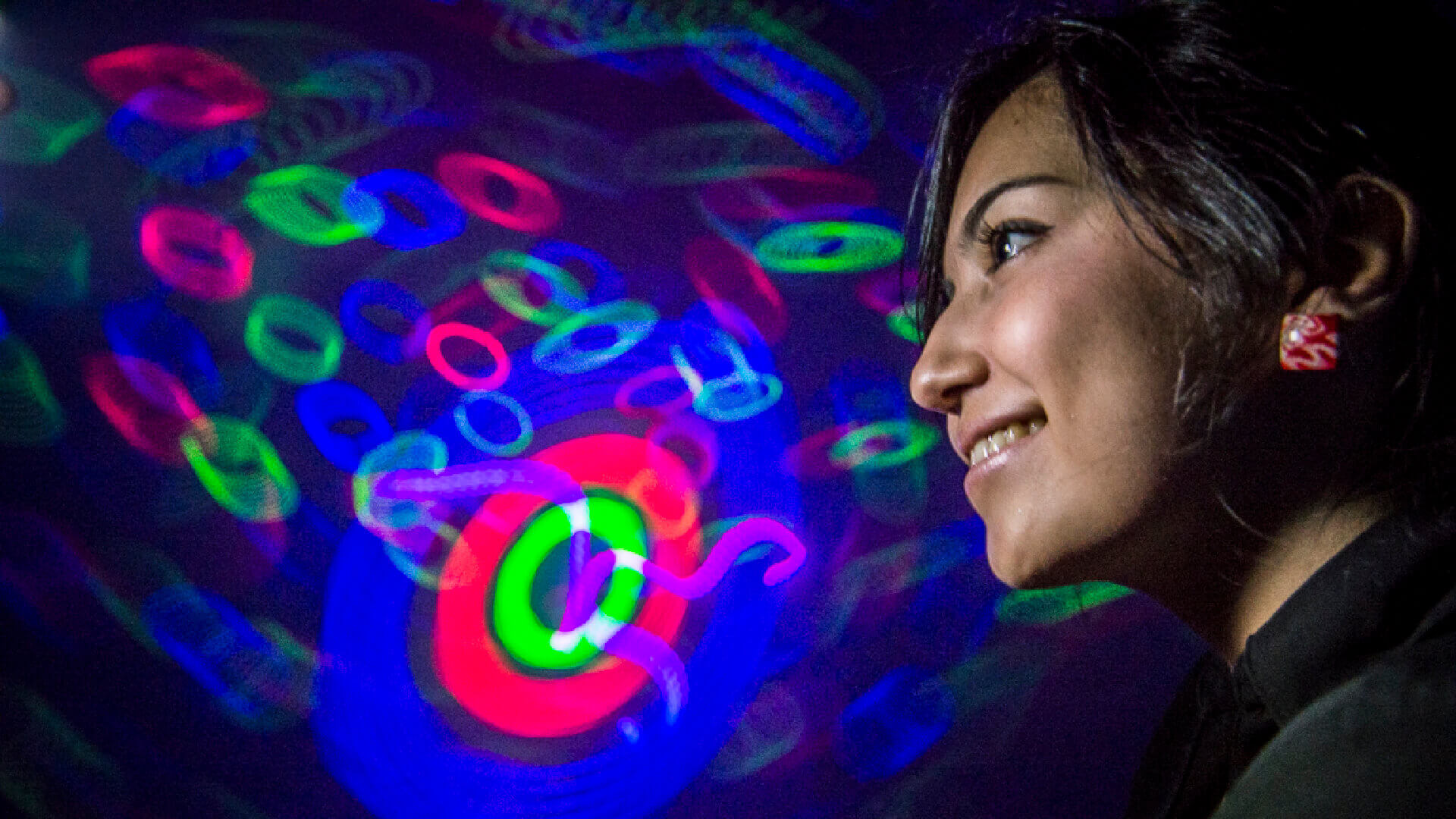 Guest experiencing a colorful laser light show at Orlando Science Center.
